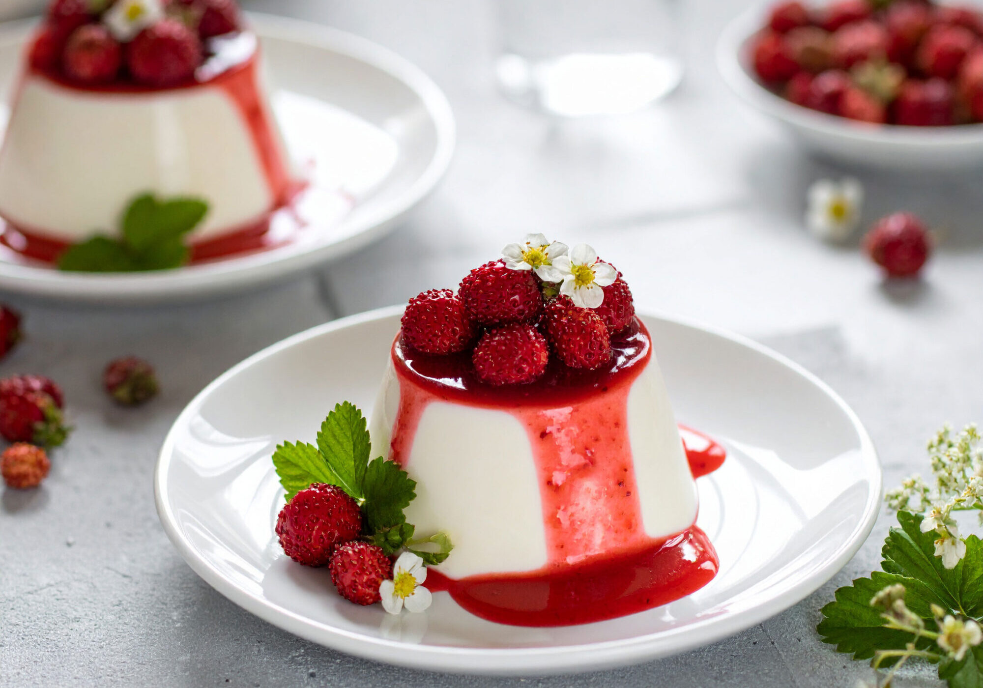 Panna-Cotta-topped-with-wild-strawberries-and-drizzled-with-berry-syrup-in-a-country-kitchen Meadowsweet, Linden Flower Panna Cotta with Wild Strawberries