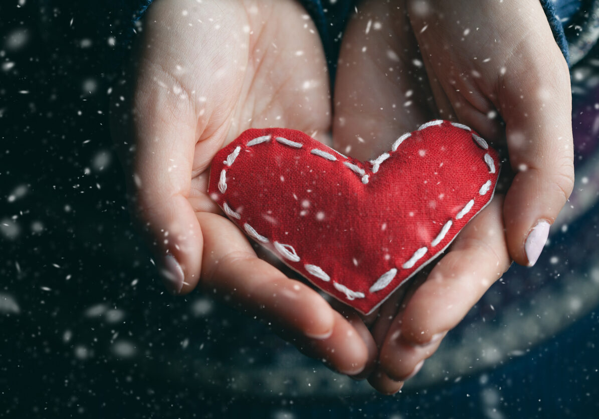 Female hands giving red heart