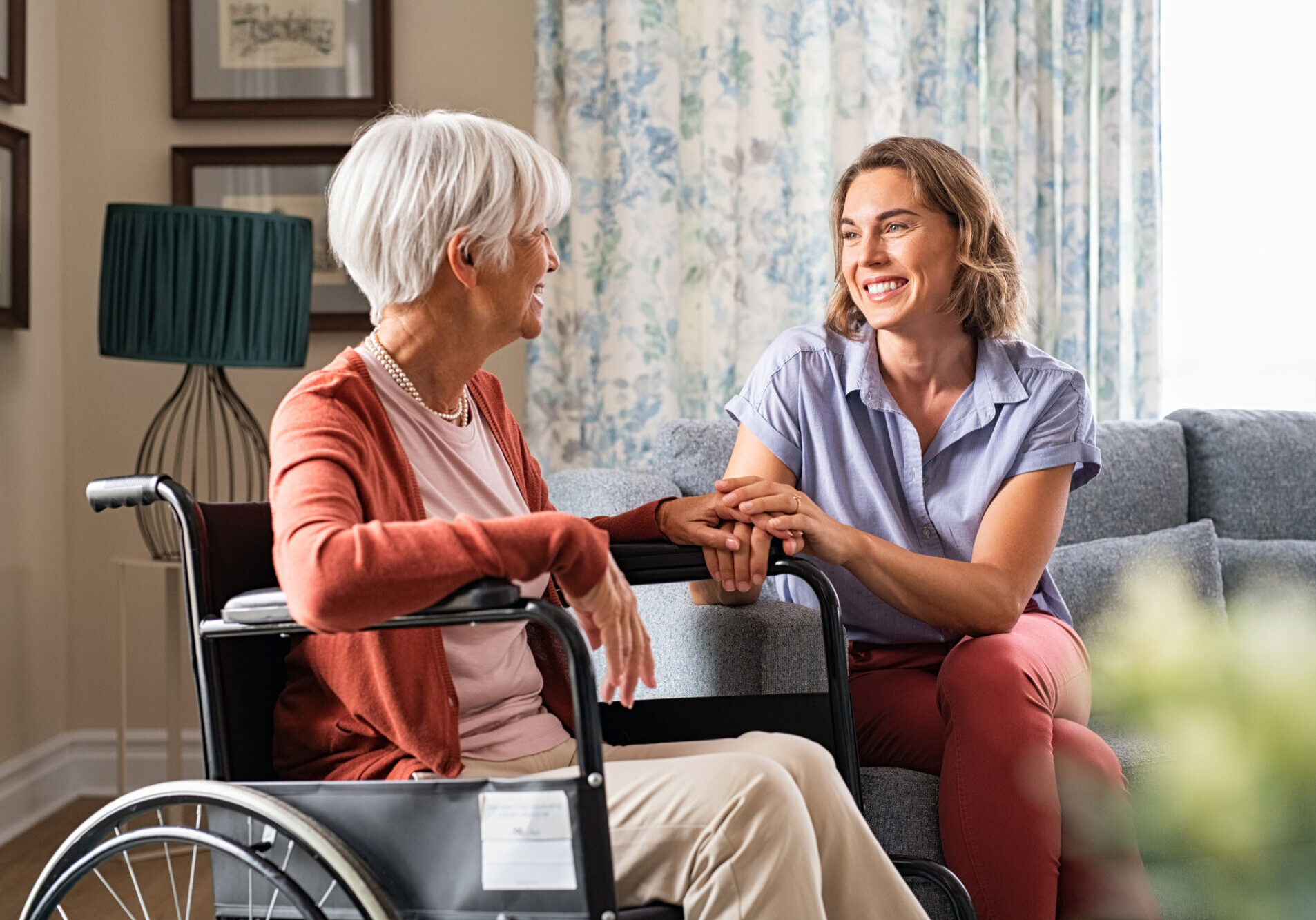 Happy adult woman visiting her elderly mother at home